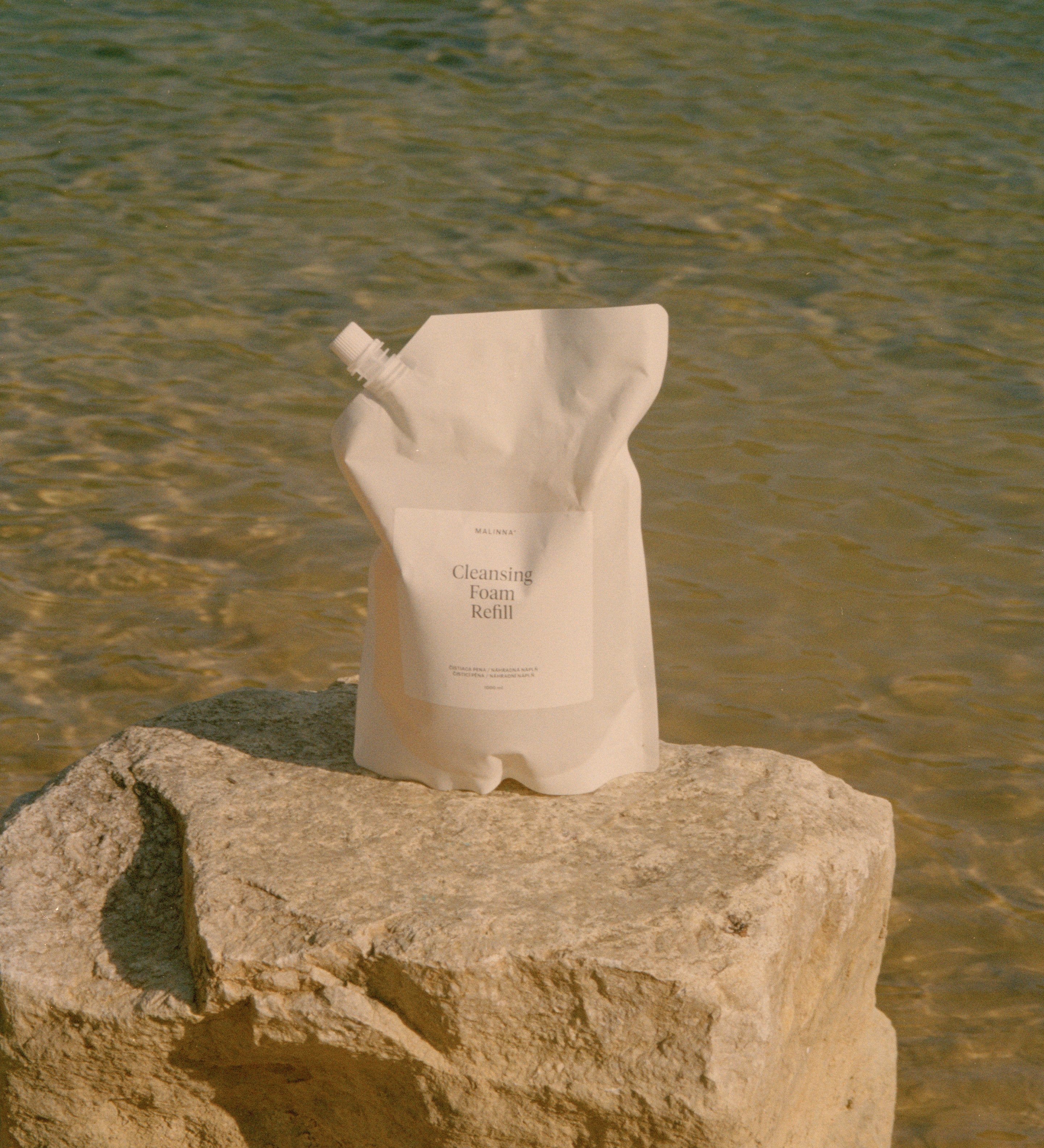 MALINNA Cleansing Foam refill na kameni v pozadi s vodou