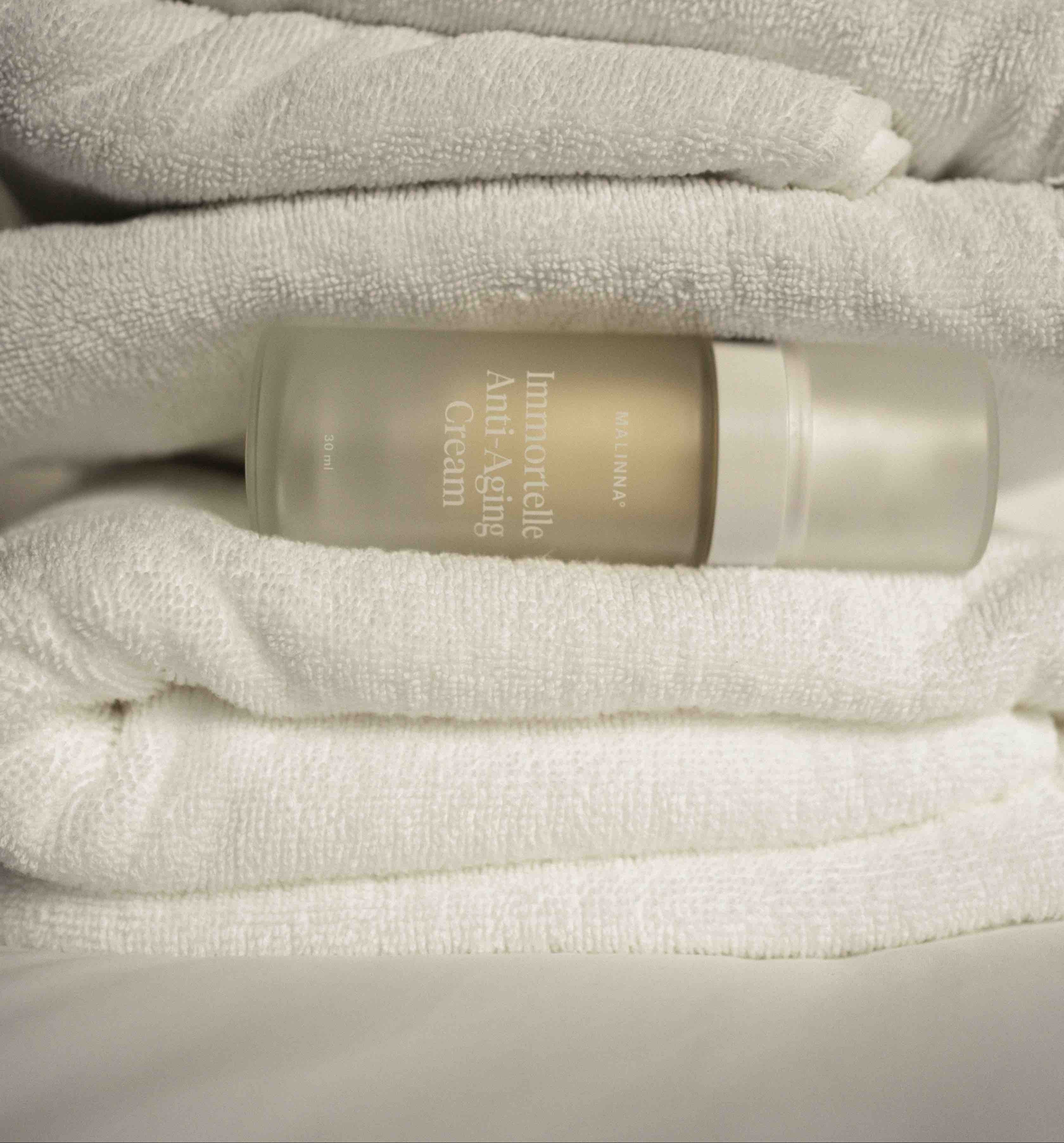 MALINNA Immortelle Anti-Aging Cream položený medzi uterákmi