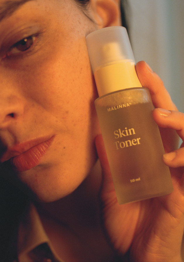 zena s krasnou pletou a revitalizacnym pletovym tonerm s protizapalovym , regeneracnym ucinkom