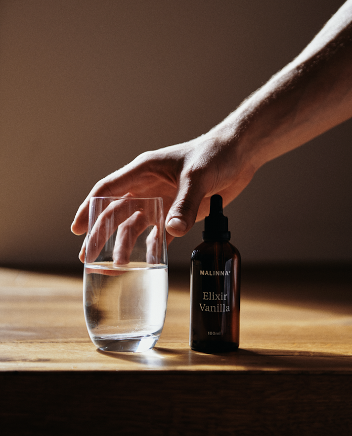 MALINNA Elixír Vanilla, nachystaný s pohárom s vodou